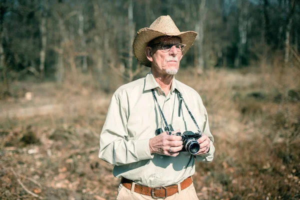 Senior man met camera — Stockfoto