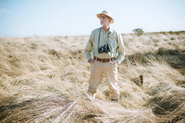 Senior tourist with camera and binocular 