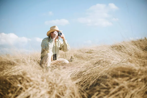 Senior man in field taking picture. — Stock Photo, Image