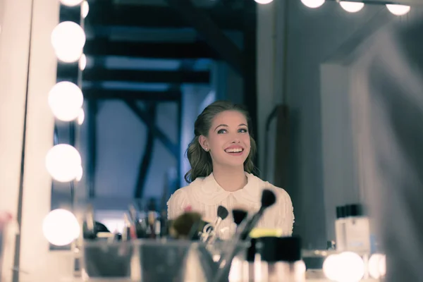 Young woman looking in theater mirror — Stock Photo, Image