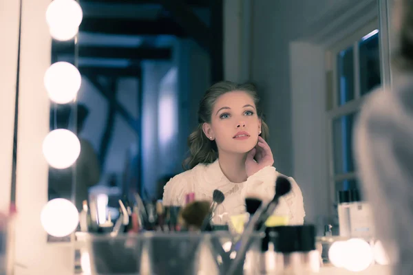 Jeune femme regardant dans le miroir de théâtre — Photo