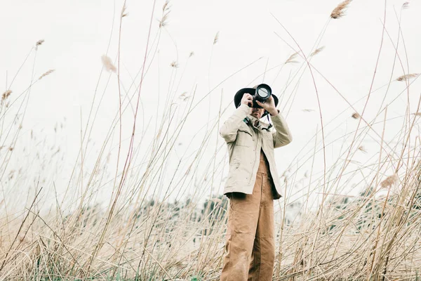 Homme au chapeau photographiant la nature — Photo