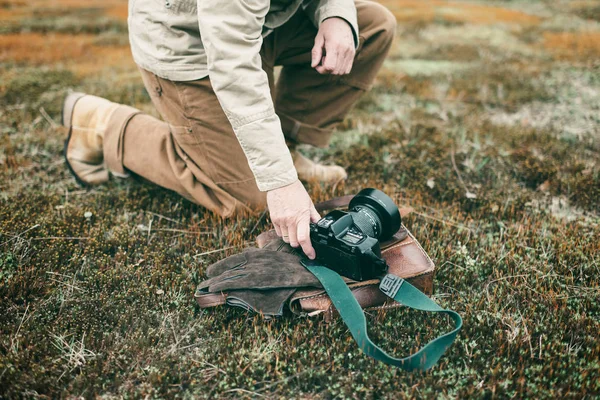 Photographer picking up camera — Stock Photo, Image