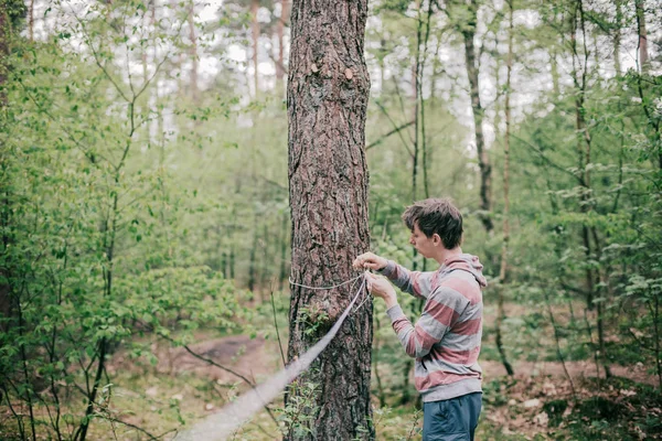 Homem amarrando corda em torno do tronco da árvore — Fotografia de Stock