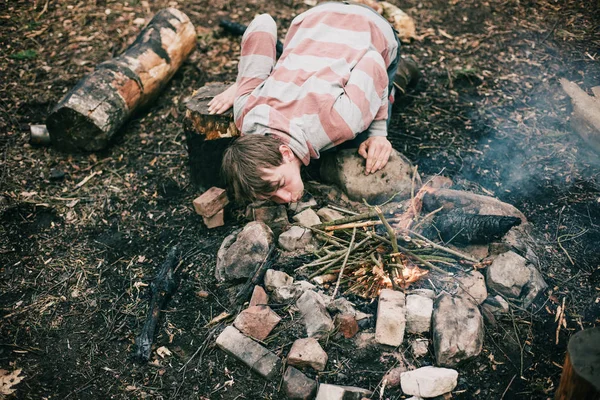 Campeur soufflant dans le feu de camp — Photo