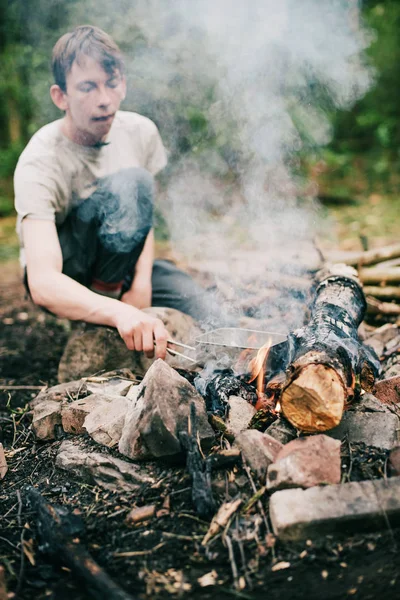 Touristin stellt Pfanne ins Lagerfeuer — Stockfoto