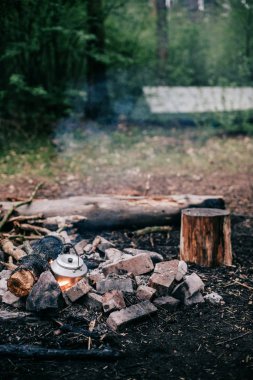 kamp ateşi üzerinde metal su ısıtıcısı