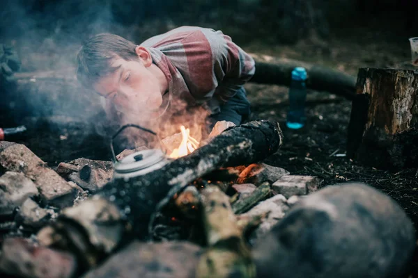 Touriste soufflant dans le feu de camp — Photo