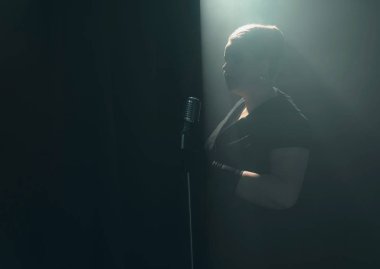 kadın dumanlı sahnede mikrofon ile