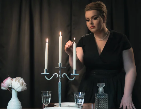 Женщина зажигает свечи на ужин — стоковое фото
