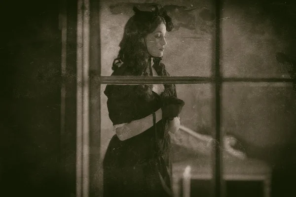 Vrouw in zwarte jurk achter venster — Stockfoto