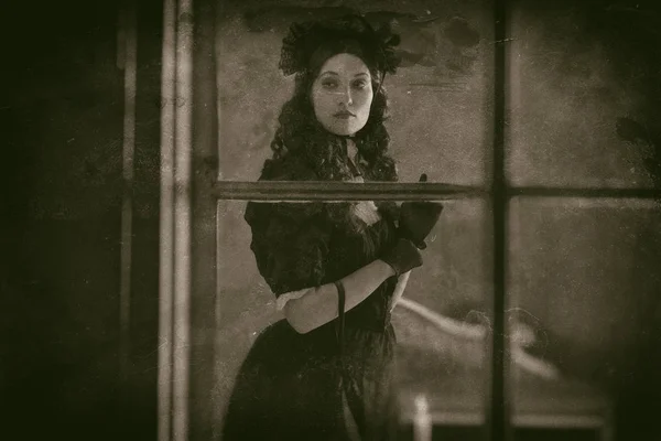 Victorian woman standing behind window — Stock Photo, Image