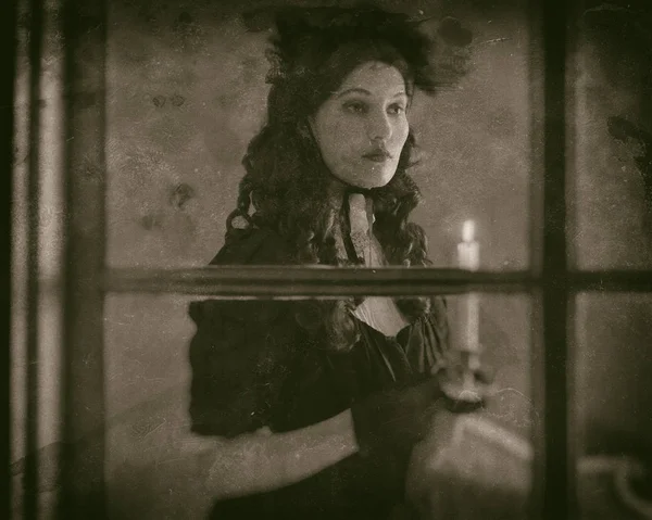 Вікторіанська жінка стоїть за вікном — стокове фото