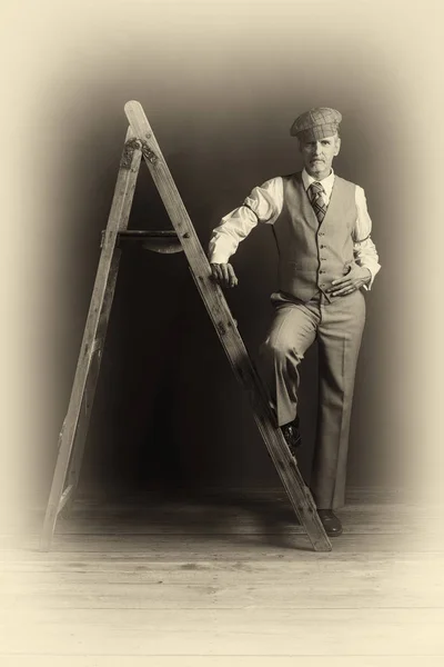 Man in pak staande op houten ladder — Stockfoto