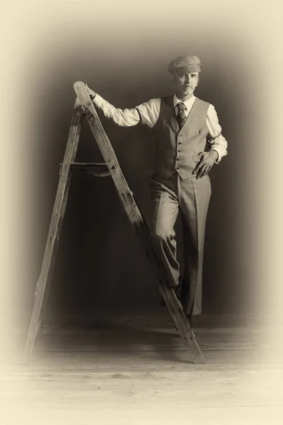 Man in suit standing on wooden ladder — Stock Photo, Image