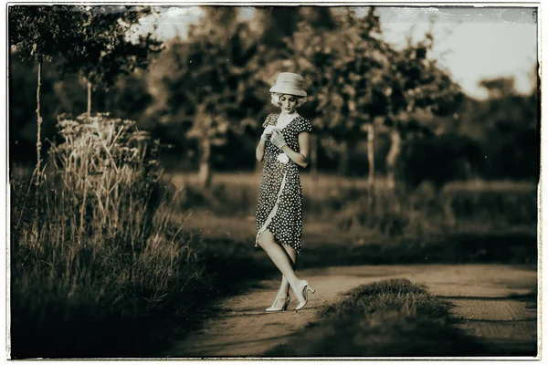 Fashion woman standing on rural road — Stock Photo, Image