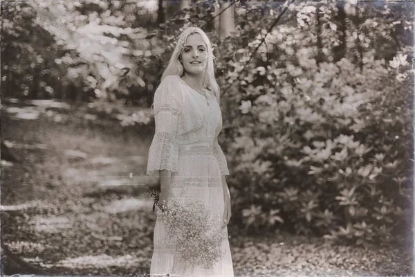 Sposa sorridente in abito bianco nella foresta — Foto Stock