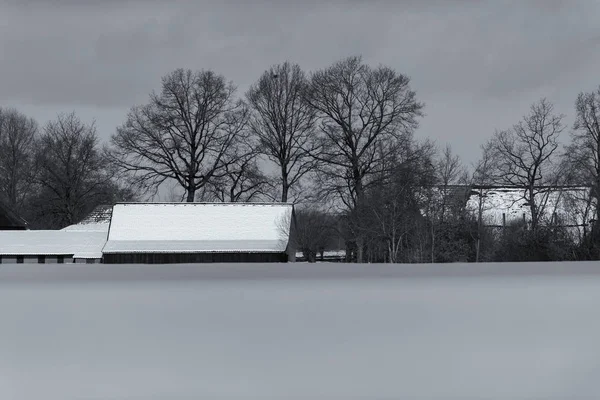Landbouwgrond met boerderij bedekt met sneeuw — Stockfoto