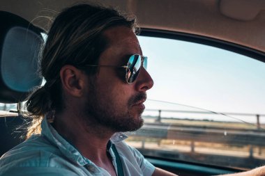 Genç adam araba kullanıyor.