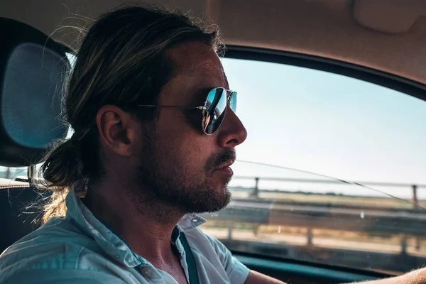 Genç adam araba kullanıyor.