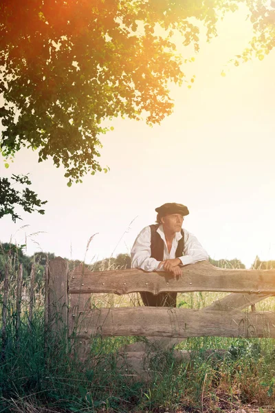 Man leaning on wooden fence — Stock Photo, Image