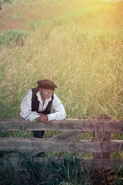 Muž opírající se o dřevěný plot — Stock fotografie