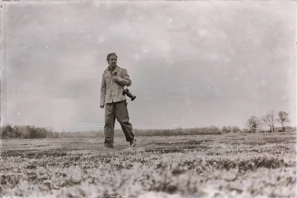 Homme avec caméra marchant sur prairie — Photo
