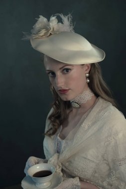 Bir fincan çay tutan kadın.