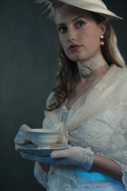 Bir fincan çay tutan kadın.