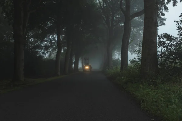 Misty country road with tractor — Stock Photo, Image