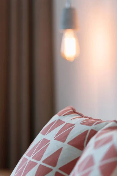 Cuscini su letto con lampadina sopra — Foto Stock