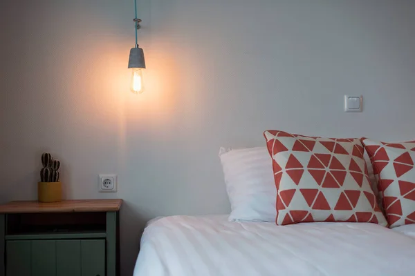 Hotel slaapkamer met gloeilamp op muur — Stockfoto
