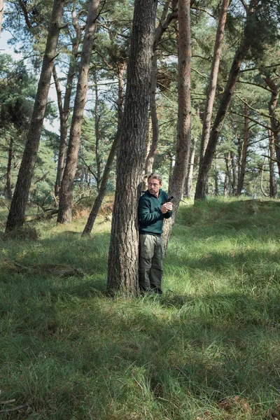 Muž s pistolí v lese — Stock fotografie