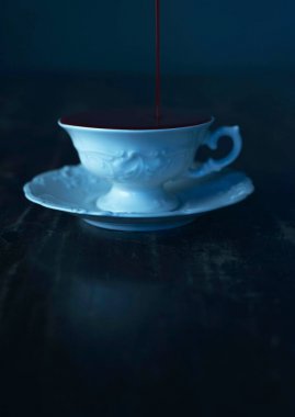 beyaz çay fincan koyu ahşap masa üzerinde içine kan dökme 