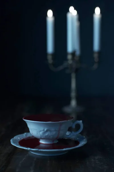 Taza Blanco Llena Sangre Con Velas Encendidas Candelabro Sobre Mesa —  Fotos de Stock