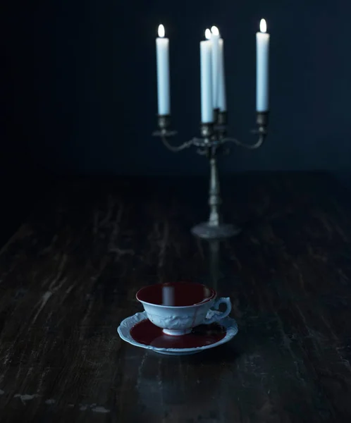 Filiżanka Biała Herbata Wypełnione Krwią Płonących Świec Świecznik Ciemny Drewniany — Zdjęcie stockowe