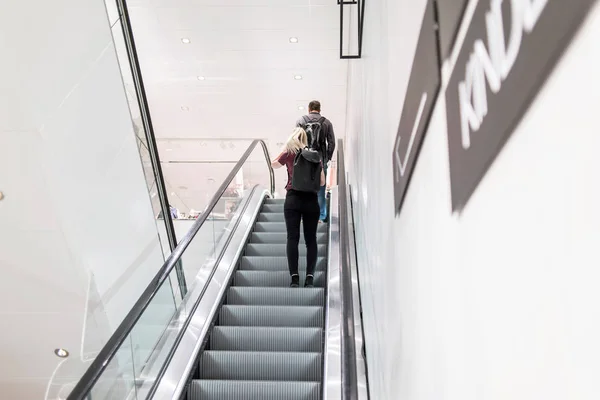 Mujer y hombre en escaleras mecánicas —  Fotos de Stock