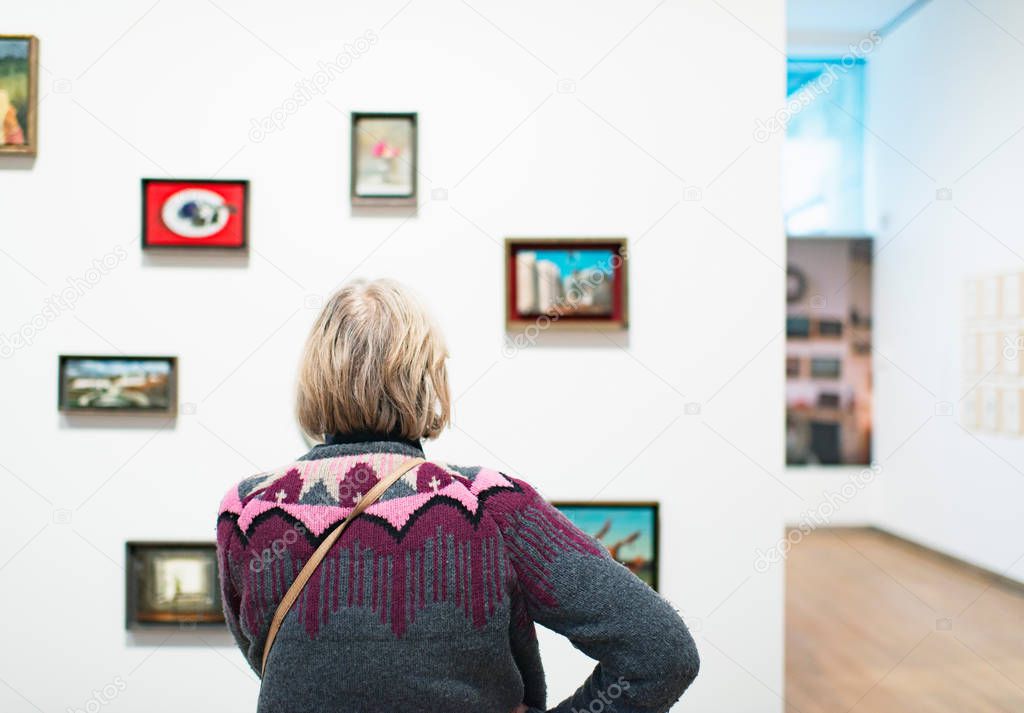 Visitor standing in front of artworks
