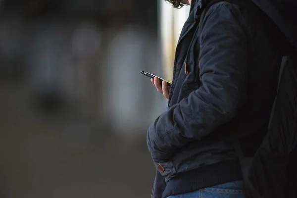 Молодой человек работает на смартфоне — стоковое фото