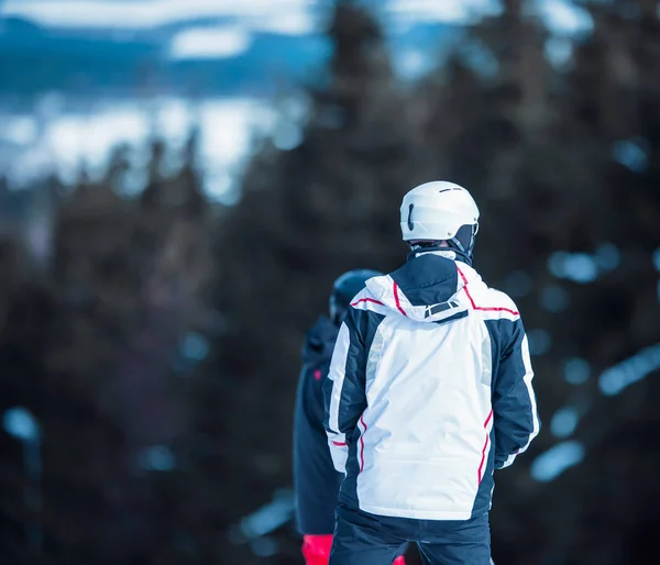 Лыжник в шлеме и белой куртке — стоковое фото