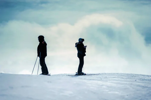 Силуэт лыжников и лыжниц — стоковое фото