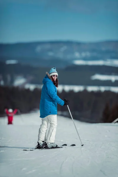 Женщина на лыжах в синей куртке — стоковое фото