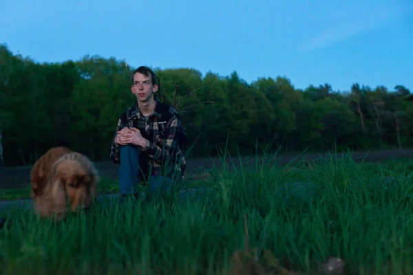 Joven con perro en la hierba — Foto de Stock