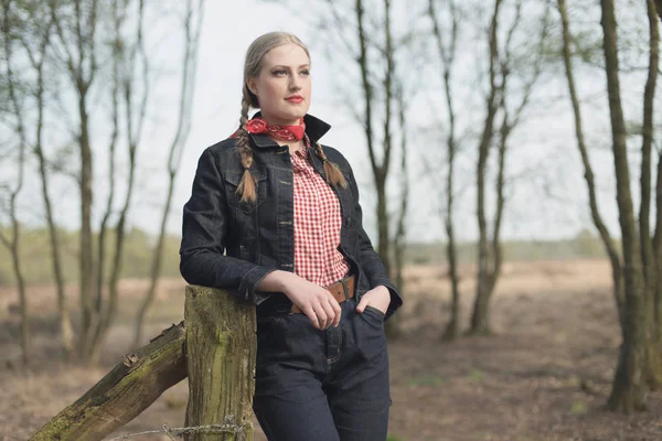 Západní dívka, opíraje se o dřevěný sloupek — Stock fotografie