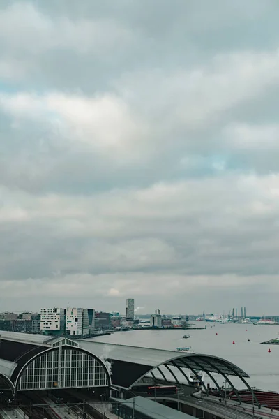 Estación central de tren de la ciudad de Amsterdam bajo el cielo nublado — Foto de Stock