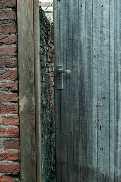 Verweerde houten tuindeur op een kier. — Stockfoto