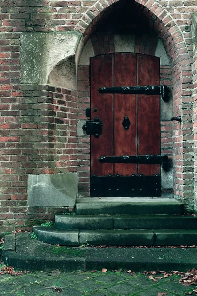 Toegangspoort van kerk met omgevallen bladeren. — Stockfoto