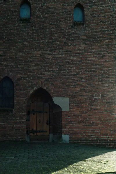 Pared de ladrillo de la iglesia con ventana y puerta de madera . — Foto de Stock