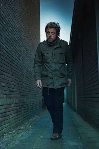 Sospechoso hombre caminando en callejón oscuro urbano . — Foto de Stock