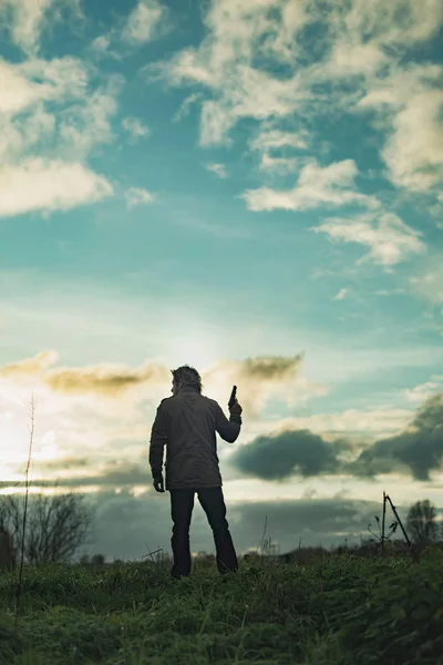 해질 녘에 시골에서 권총을 든 남자. — 스톡 사진
